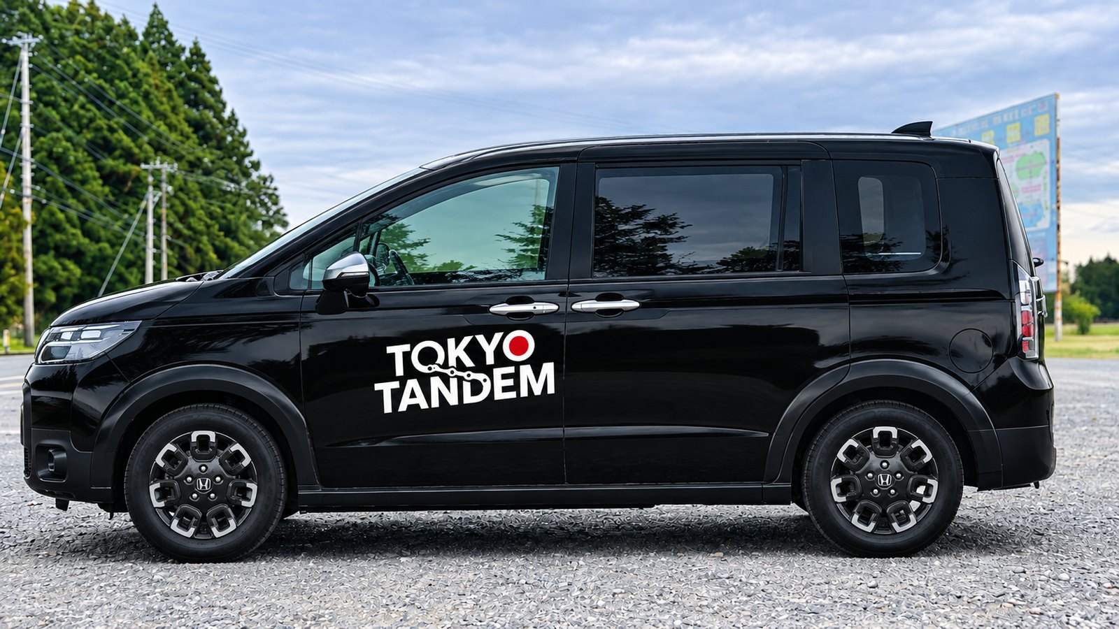 東京タンデムの応援サポートカー。黒い乗用車のドアにTOKYO TANDEMのロゴ